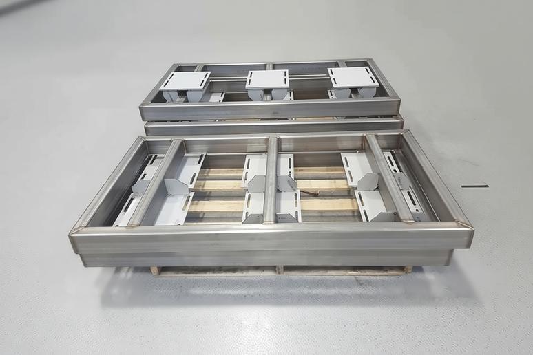 Custom fabricated industrial stainless steel metal frames complete and stacked on pallet.