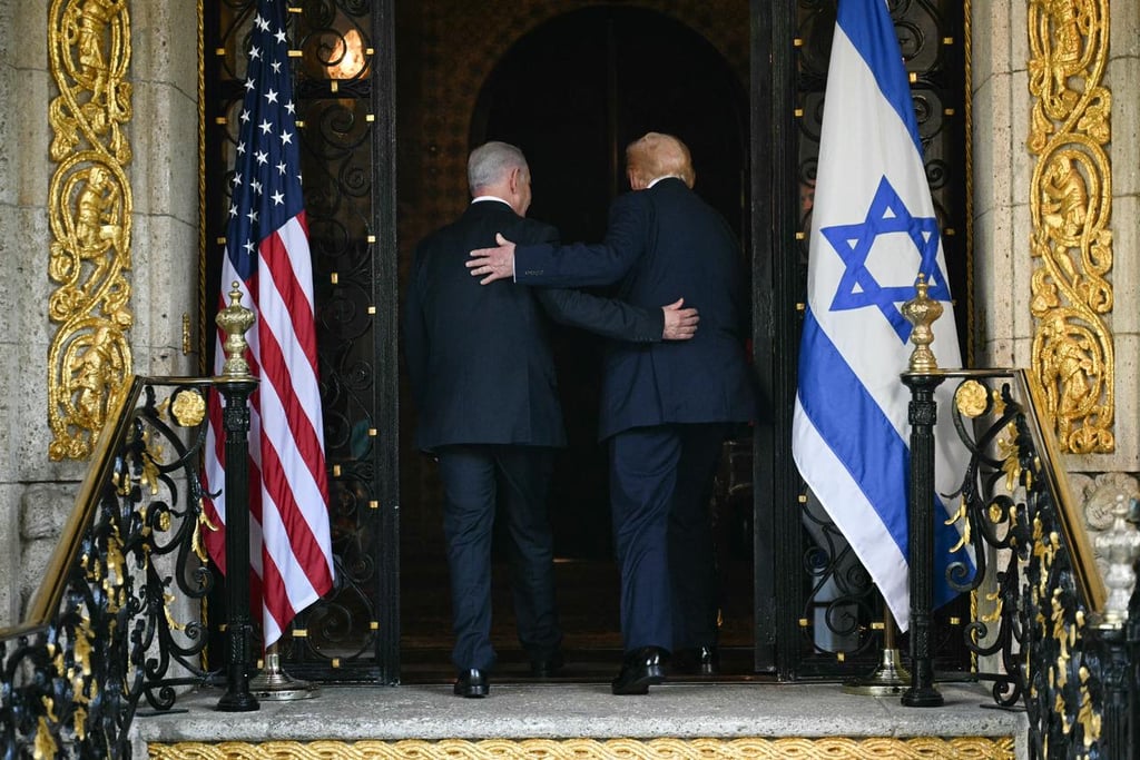 Netanyahu and Trump entering together between the American Flag and the Flag Of Israel