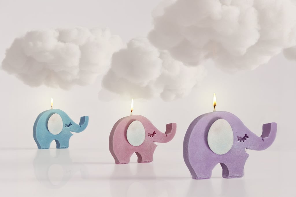 Velas con forma de elefante, de color azul, rosa y morado, iluminadas con un toque de fantasía