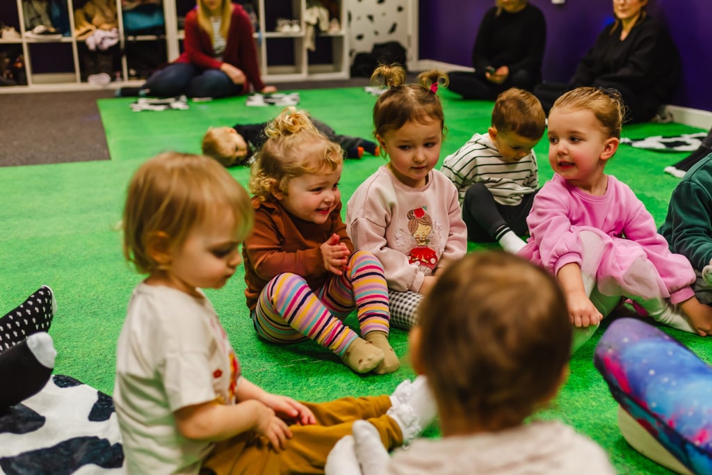 Young children as friends,sitting together watching farmer Becca in class. 