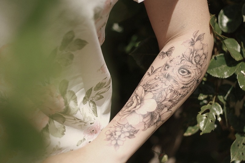 Une femme avec un tatouage sur le bras chouette hiboux