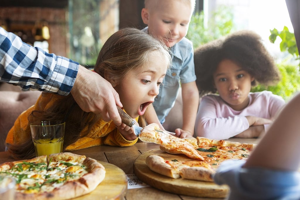 a family eating pizzas at a restaurant