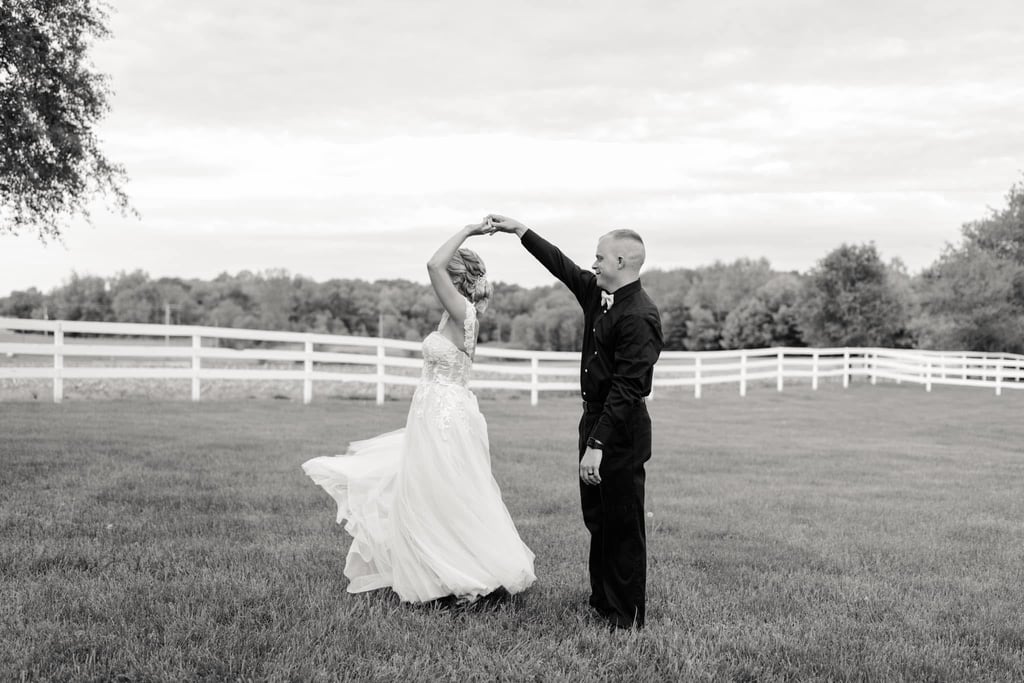 a bride and groom dancing in a field