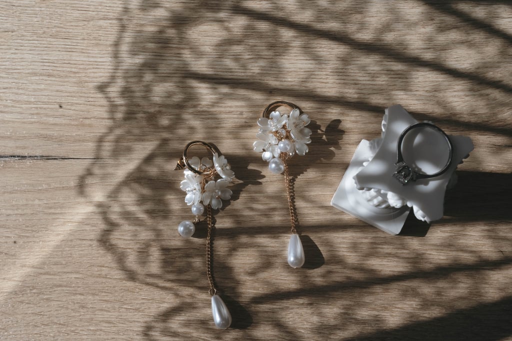 Elegant gold flower pearl drop earrings and a diamond ring wedding preparation