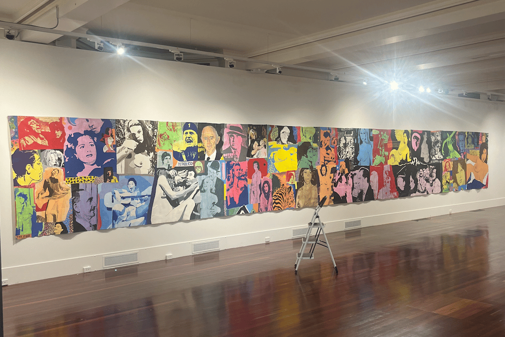A large tapestry style Richard Larter painting installed on a batten in a gallery space