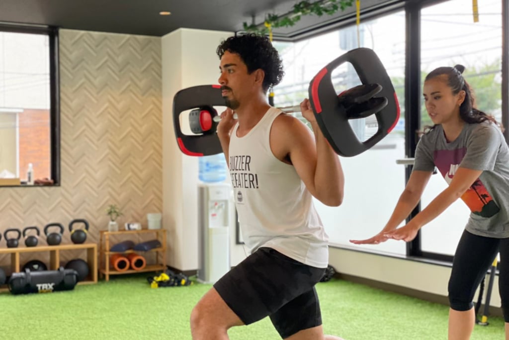 衆院選の選挙割を実施するジムフィールド堺東スタジオで、トレーナーが利用者にスクワット指導を行う様子｜堺市のニュースならサカイタイムズ