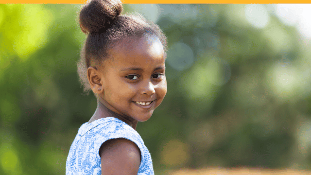 A cute young girl playfully looking at you