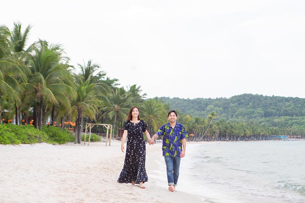 Couple walking hand in hand along Khem Beach