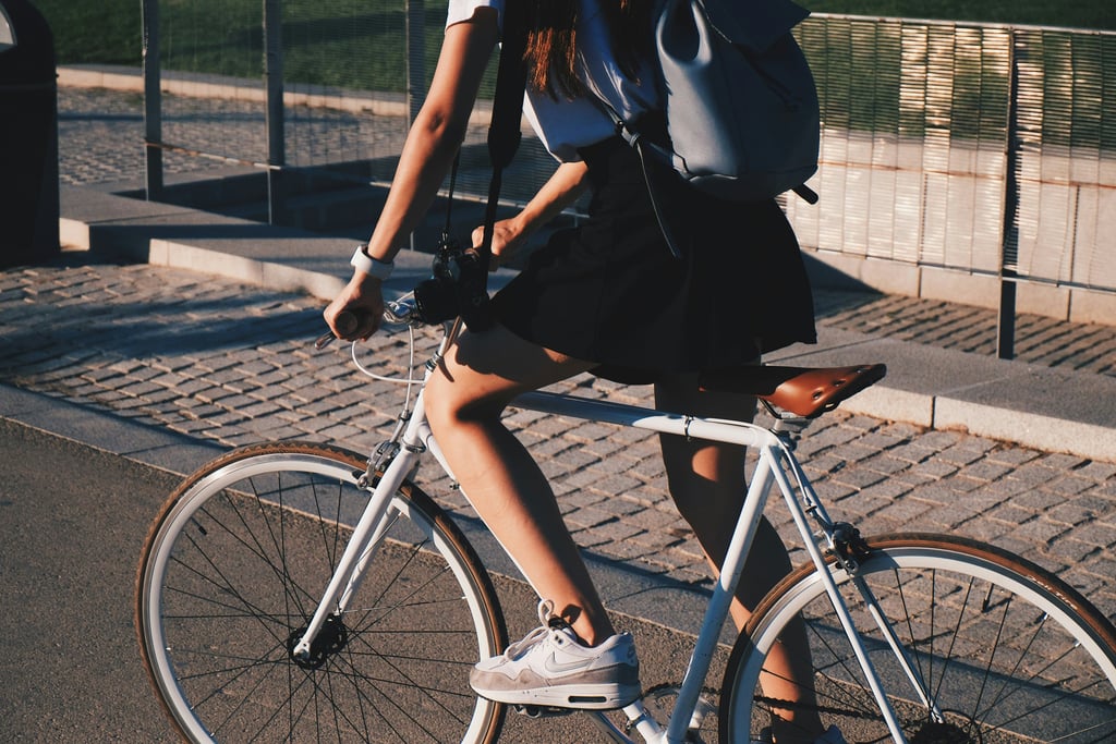 a woman riding a bicycle with a backpack on it