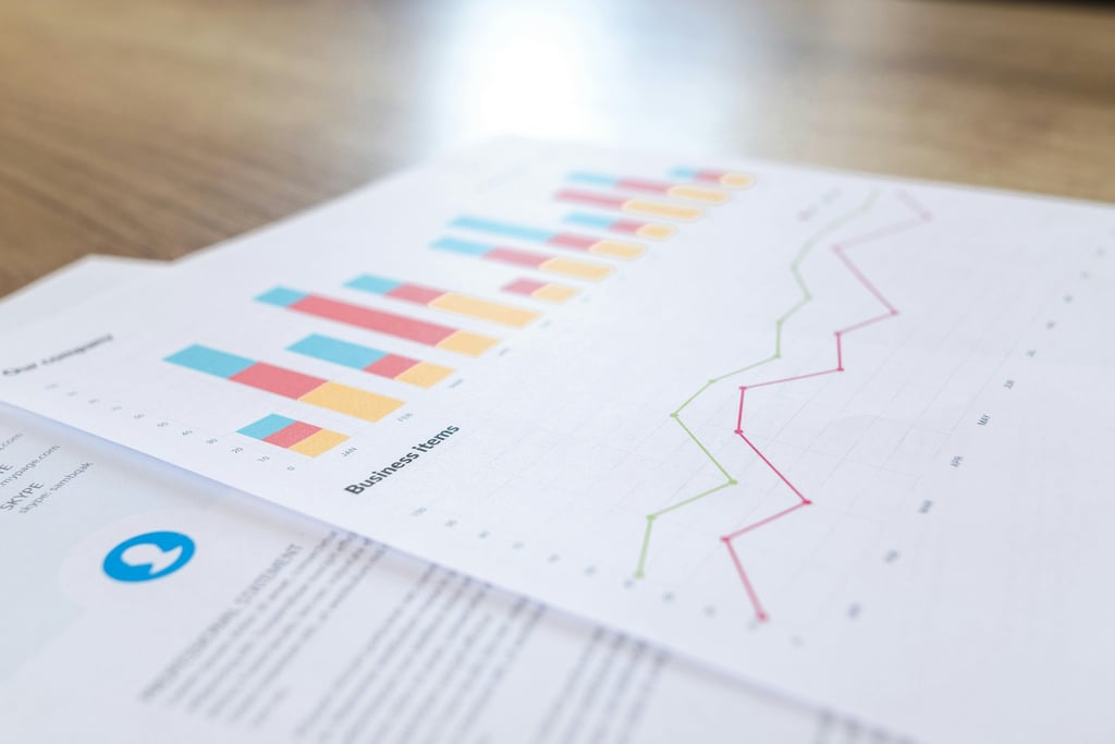 Two overlapping sheets of paper on a tabletop, the top one covered in graphs, a bar graph and a line graph.