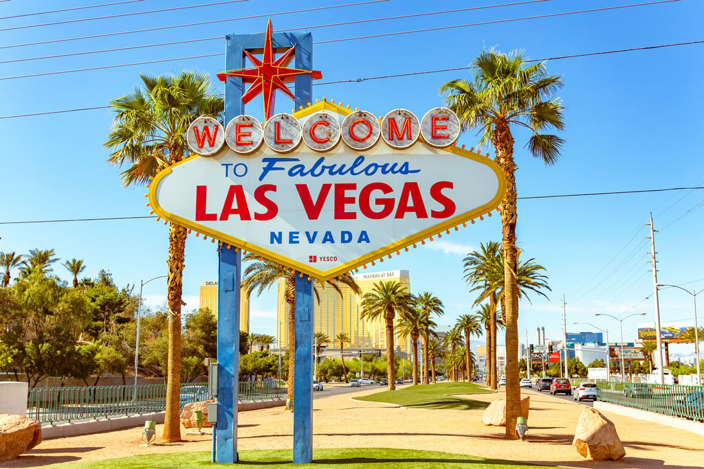 The iconic Welcome to Fabulous Las Vegas sign on the Las Vegas Strip surrounded by palm trees.