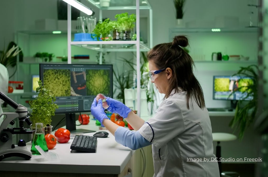 a woman in a lab coat and gloves is holding a vegitabla which is ues in keto diet