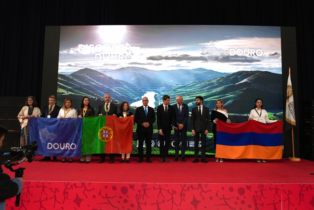 Dignitaries holding Portugal and Armenia flags at a Douro region tourism event.