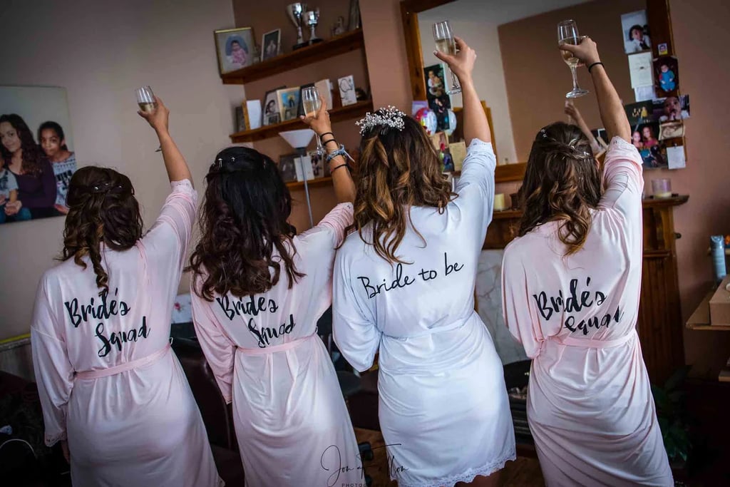 bride and bridemaid raising a glass of champagne