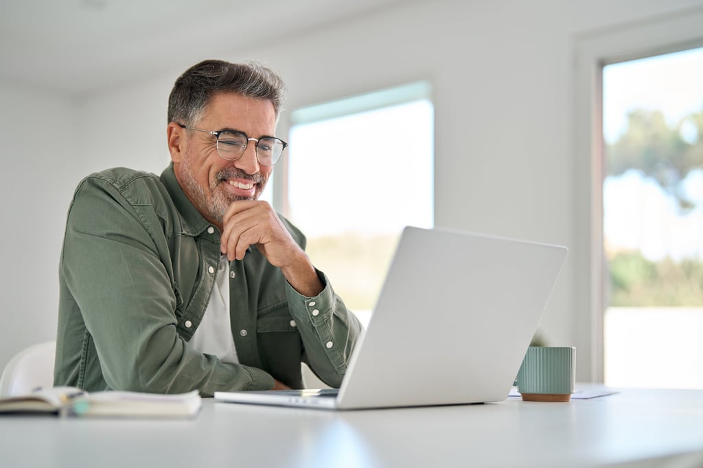 Man smiles as he speaks to mediator on his laptop