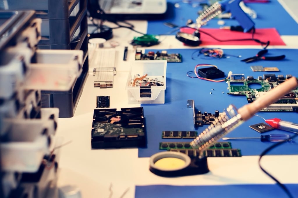 Electronics workstation with tools and circuit boards for hardware development.