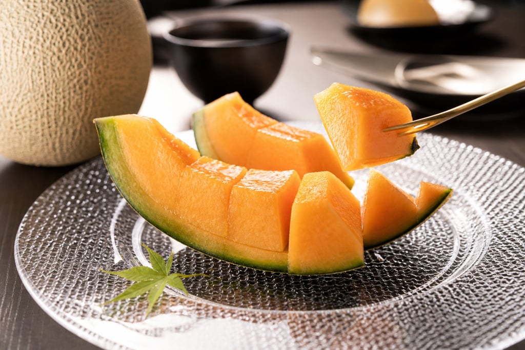 Slices of fresh ripe cantaloupe melon served on a glass plate for a healthy fruit dessert.