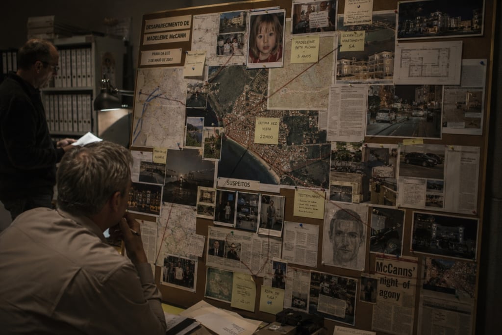 Investigators studying a detailed police bulletin board about the Madeleine McCann disappearance case.