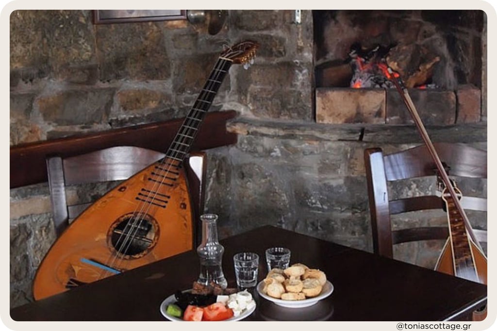 Rustic table set with a lyra, Cretan lute, glasses, and plates of local food inside a stone