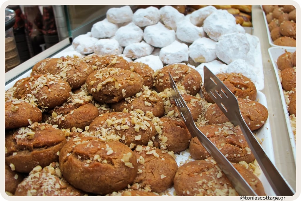 Tray of Greek Christmas sweets: melomakarona cookies with walnuts and snowy kourabiedes