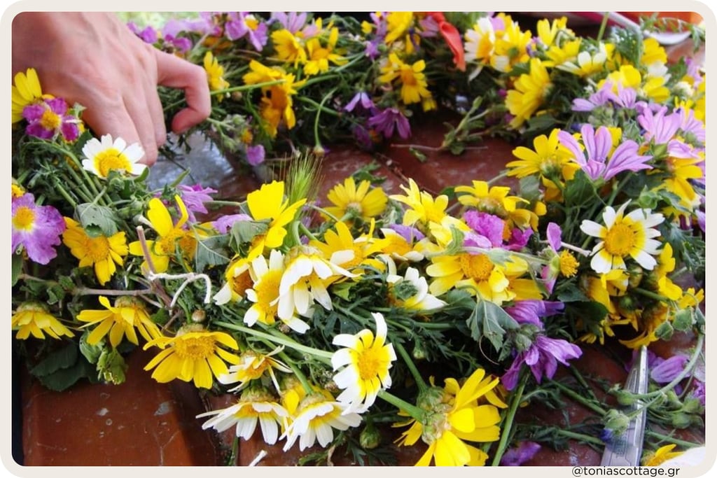 Hands weaving a colourful wildflower wreath for May Day in Crete.
