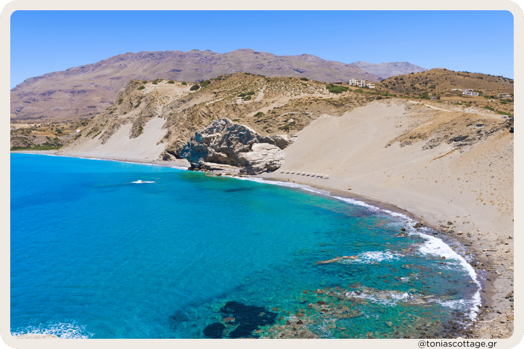 Agios Pavlos Sandhills in Crete, Greece with a scenic sea view, featuring sunbathers in the distance