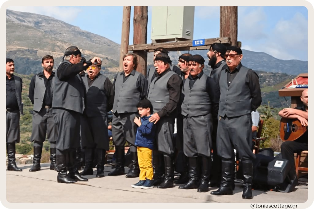Men and boys in black Cretan clothing standing outdoors