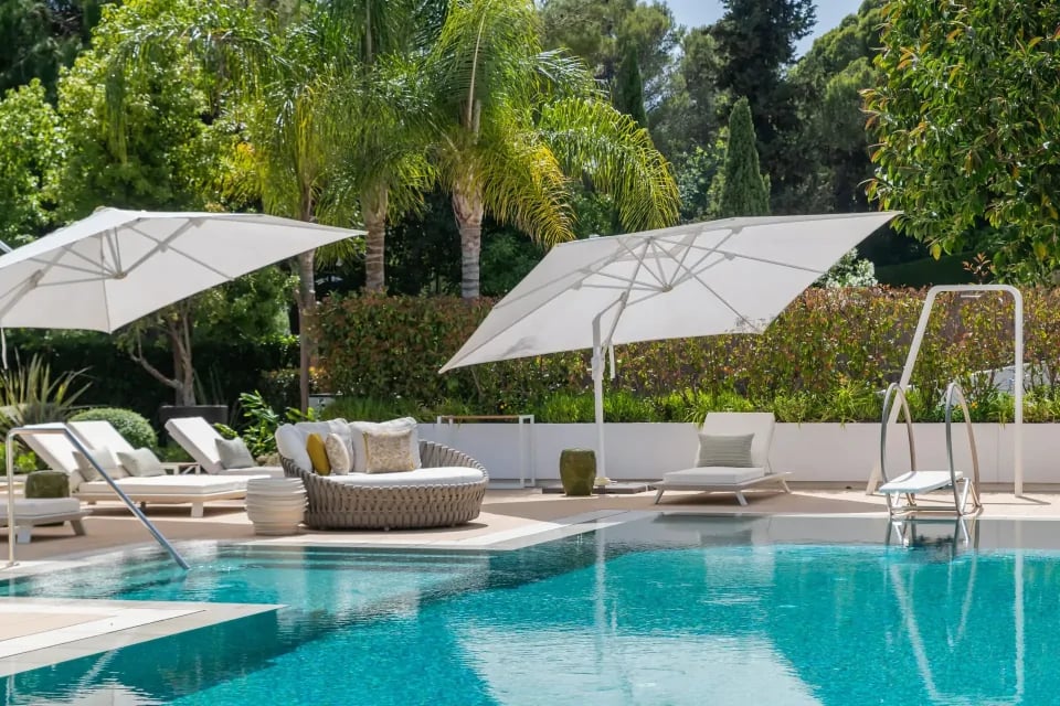 Poolside daybeds with umbrellas at Villa Serenity gardens