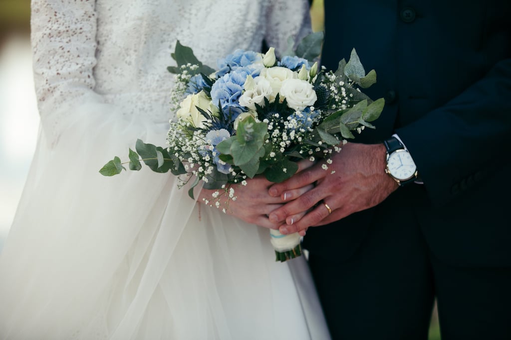 Des mariés en train de tenir le bouquet/a bride and groom holding a bouquet of flowers