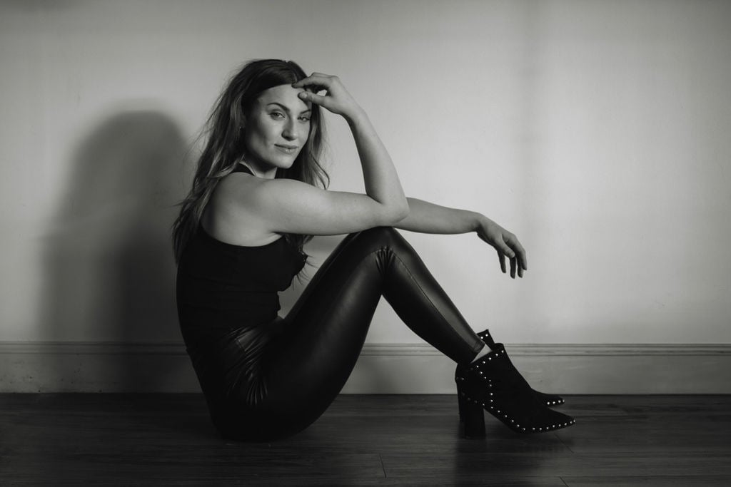 a woman in black and white photo of a woman in leather pants and boots