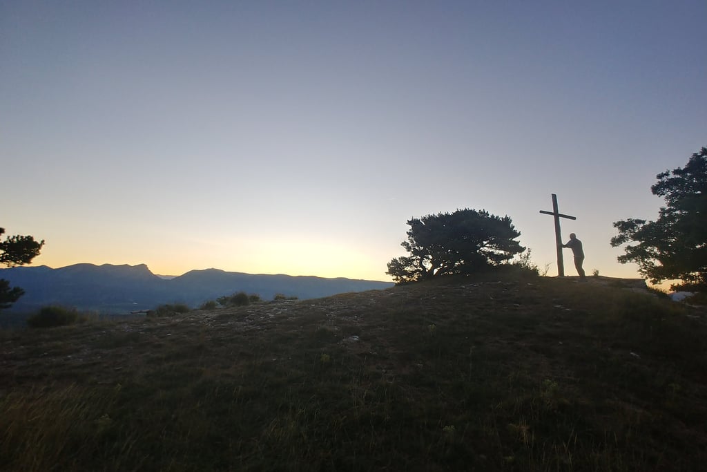 Holding a wooden cross near Chapelle Saint-Maurice, Drôme, Rhône-Alpes, France