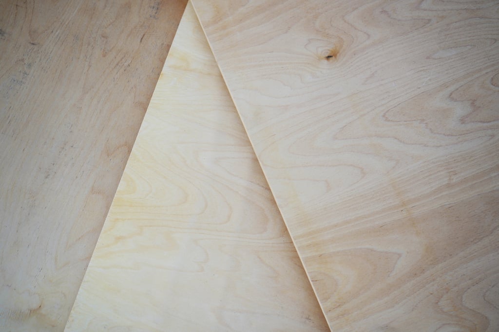 Close-up of stacked sheets of high-quality birch plywood showing wood grain and layered edges.