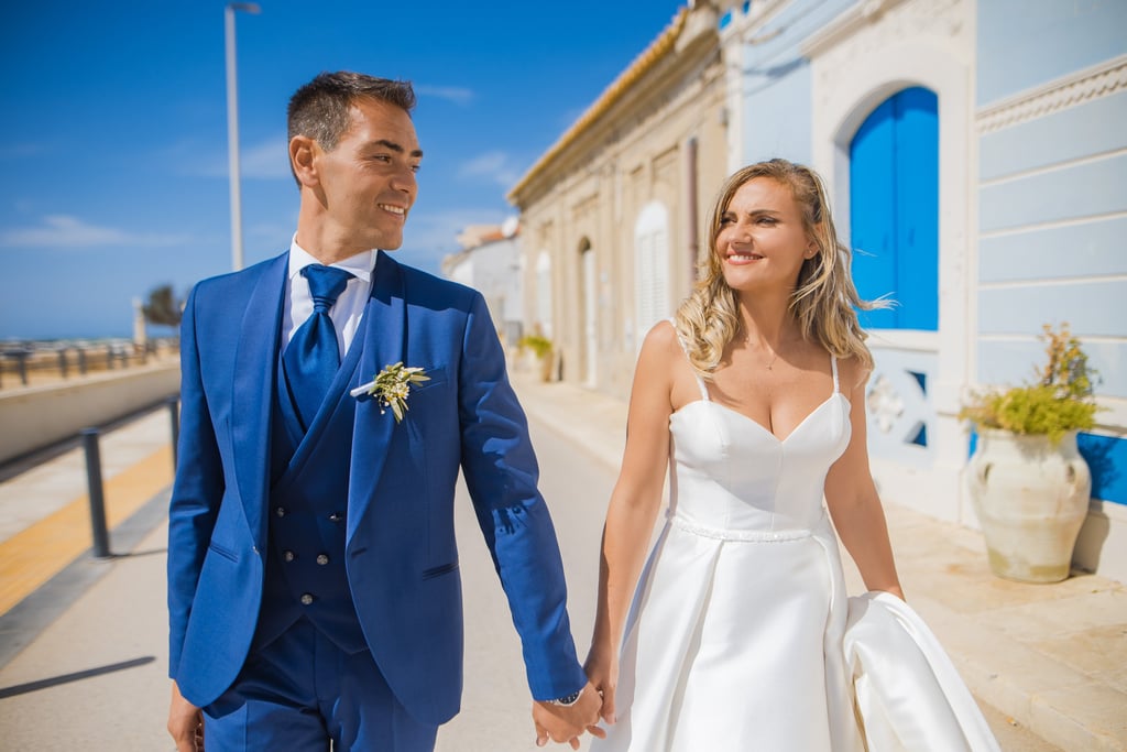 sposo e sposa che passeggiano al mare