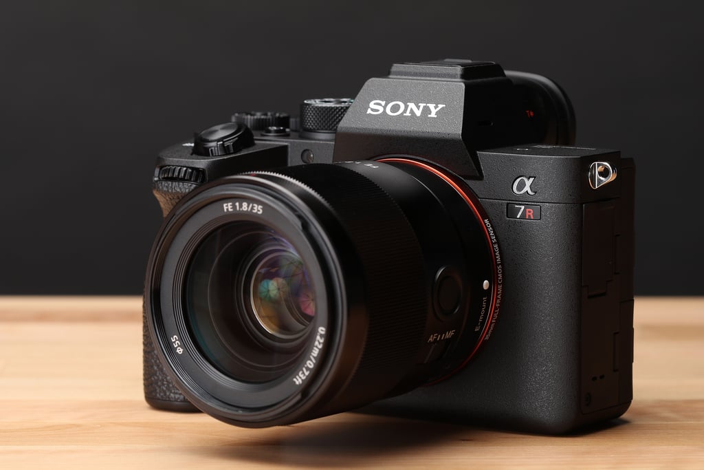 Sony Alpha 7R mirrorless camera with FE 35mm f1.8 lens on a wooden surface.