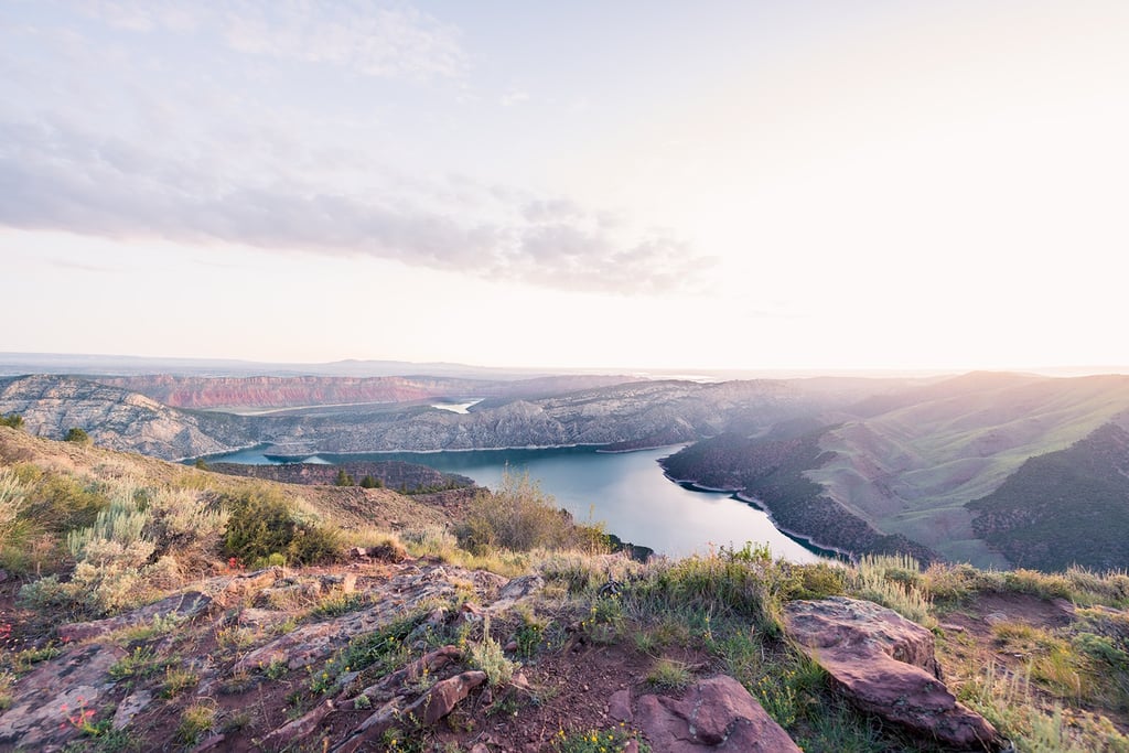 Aerial view of Flaming Gorge Reservoir at sunrise with scenic mountain ridges and canyon landscape.