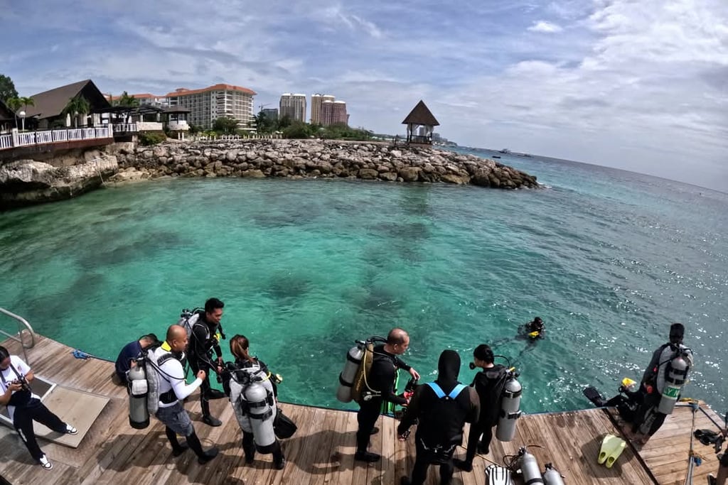 Divers in the jetty port before jumping down into the clear waters of Shangrila