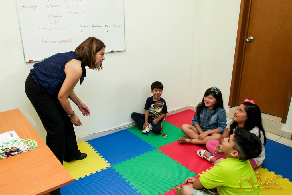 a woman standing in front of a group of children