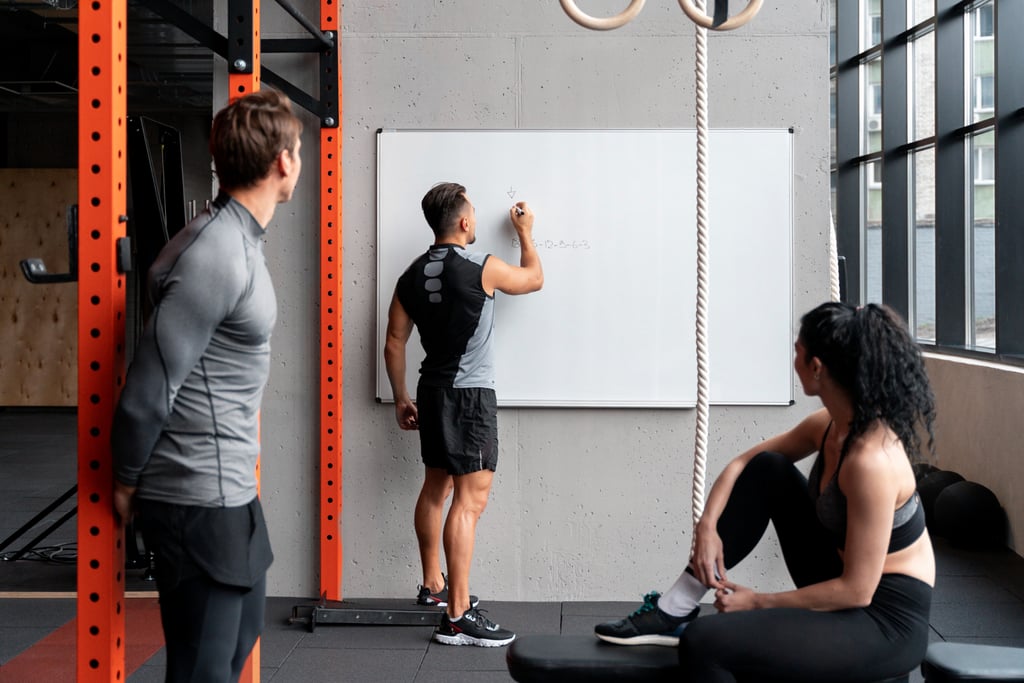 personal trainer writing workout plan on board