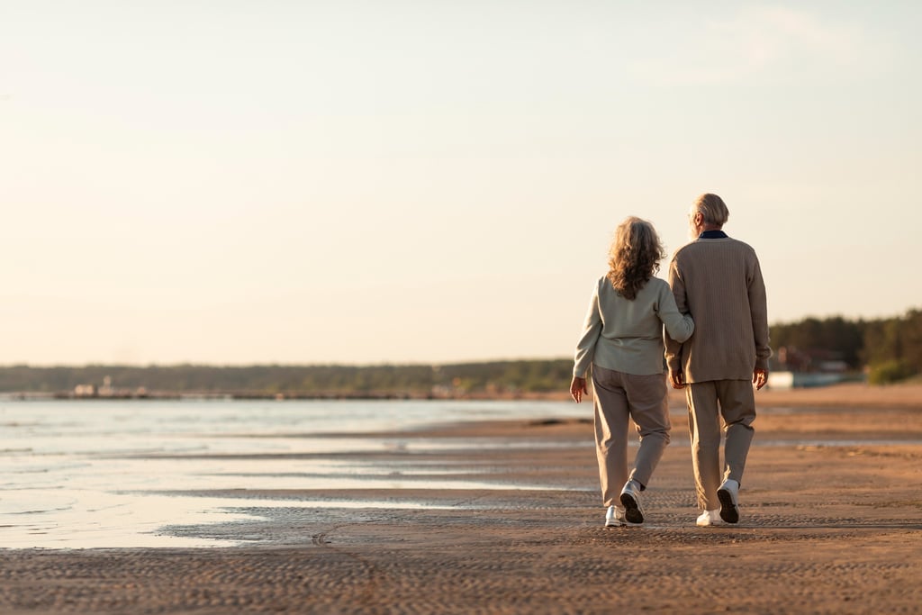 hombre y mujer jubilados andando por la playa
