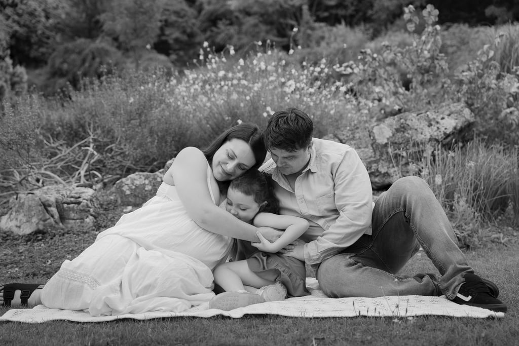 Black and white image family of three holding each other close