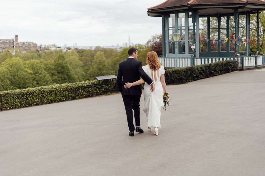 bride and groom holding each other and walking on the street with view