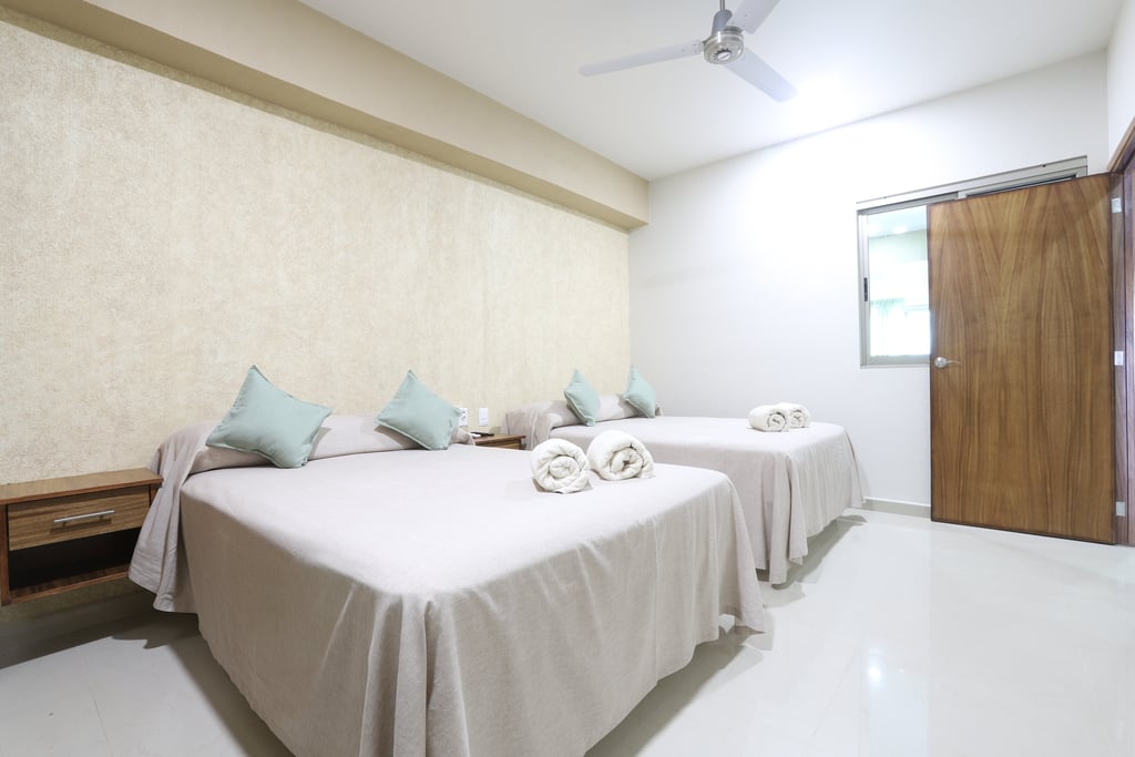 Habitación con dos camas matrimoniales en bungalows aleday