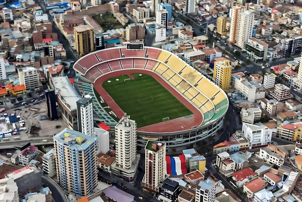 Vista interna do Estádio Hernando Siles em La Paz, mostrando as arquibancadas coloridas e a pista de atletismo.