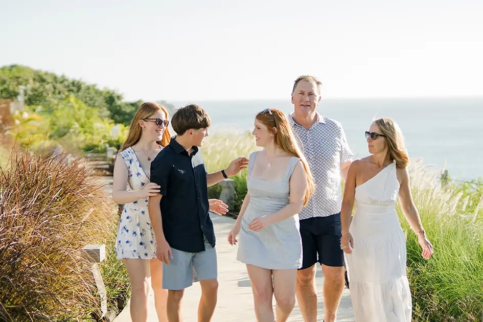 Family walking together beside the ocean cliffs during a family photography session at AYANA Resort Bali