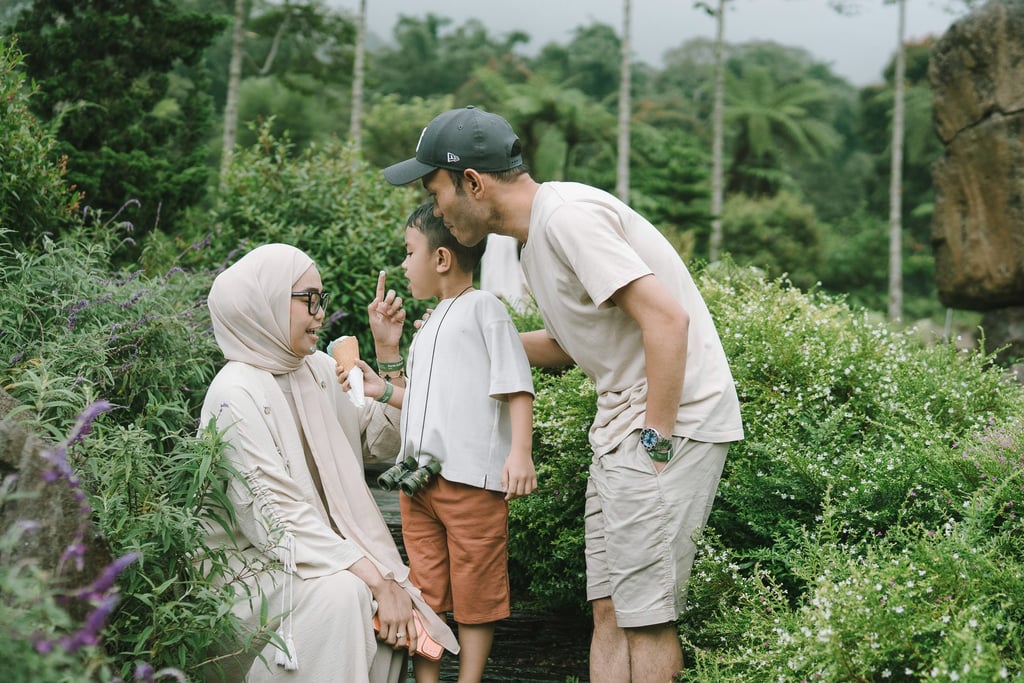 Father kissing mother during a family photography session at Bali Farm House Bedugul Bali.