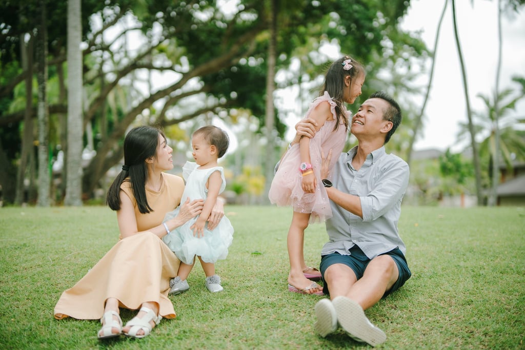 Intimate family moment at The Laguna Nusa Dua Bali, natural luxury family photography in a tropical garden setting.