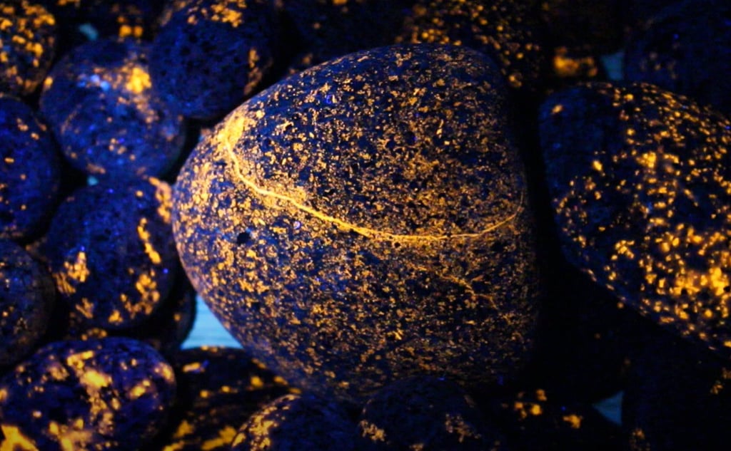 Orange glowing yooperlite rocks under 365nm uv light.