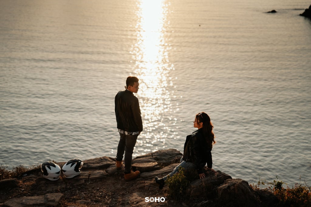 a couple of people standing on a rock
