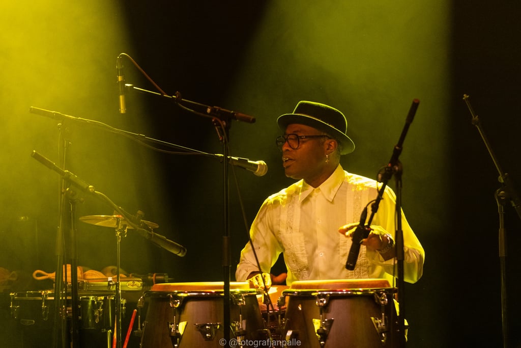 a man in a hat playing percussion congas