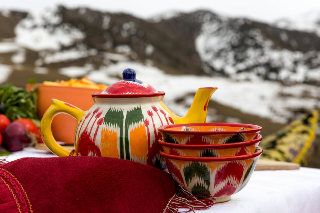 red and yellow ceramic teapot on red textile by Daniel Fox